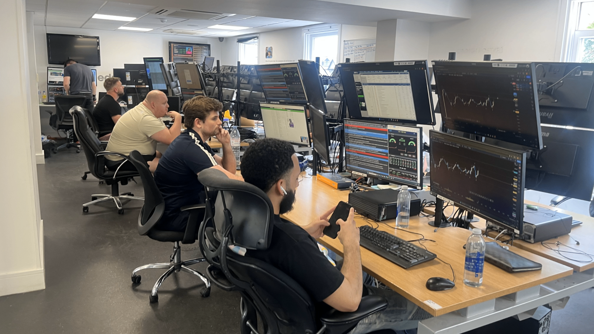 Traders at multi-monitor workstations inside the Educate2Trade office in Bromley